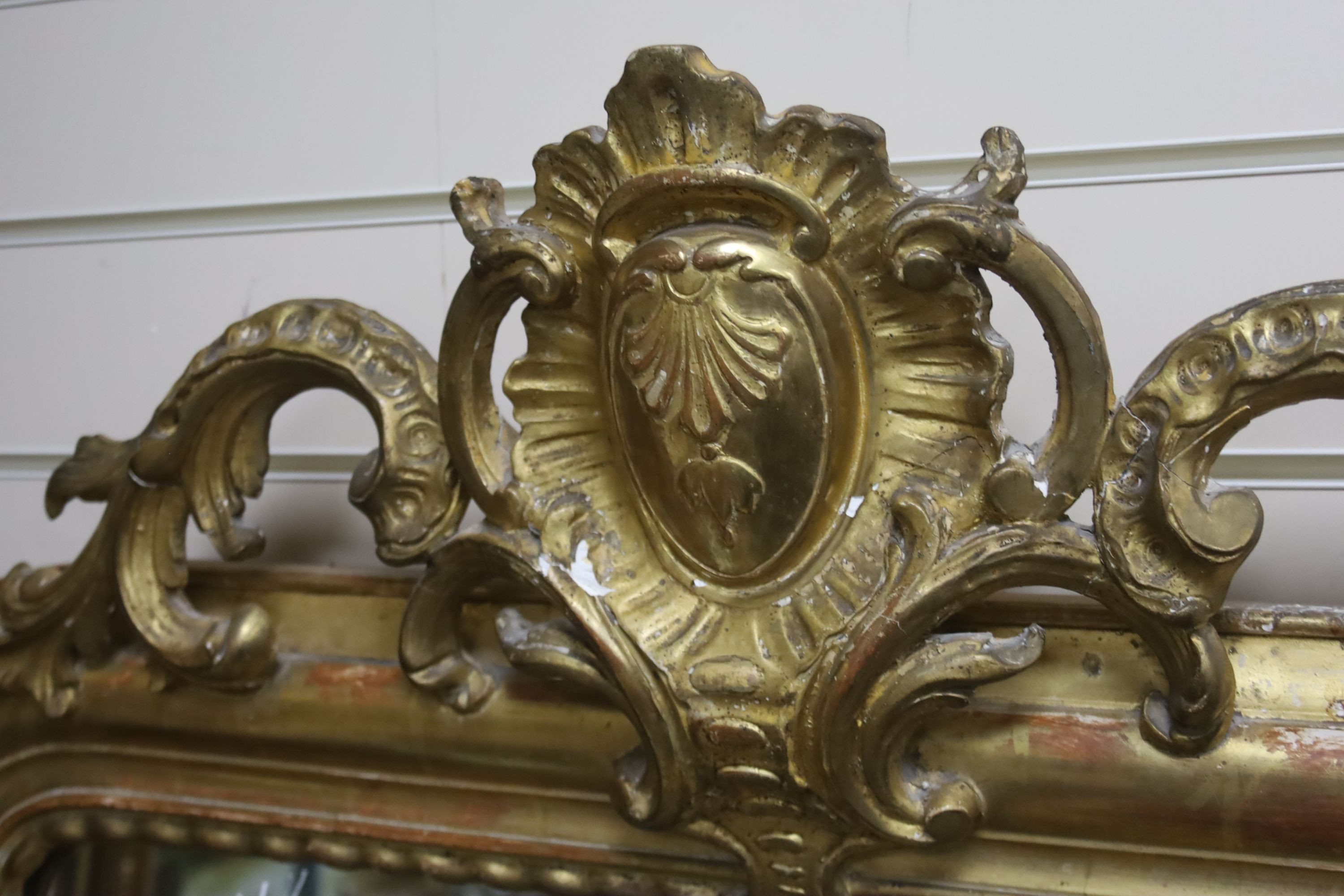 A 19th century French overmantel mirror, giltwood and gesso with channelled frame and scroll with cabochon crest detail, width 98cm, height 164cm